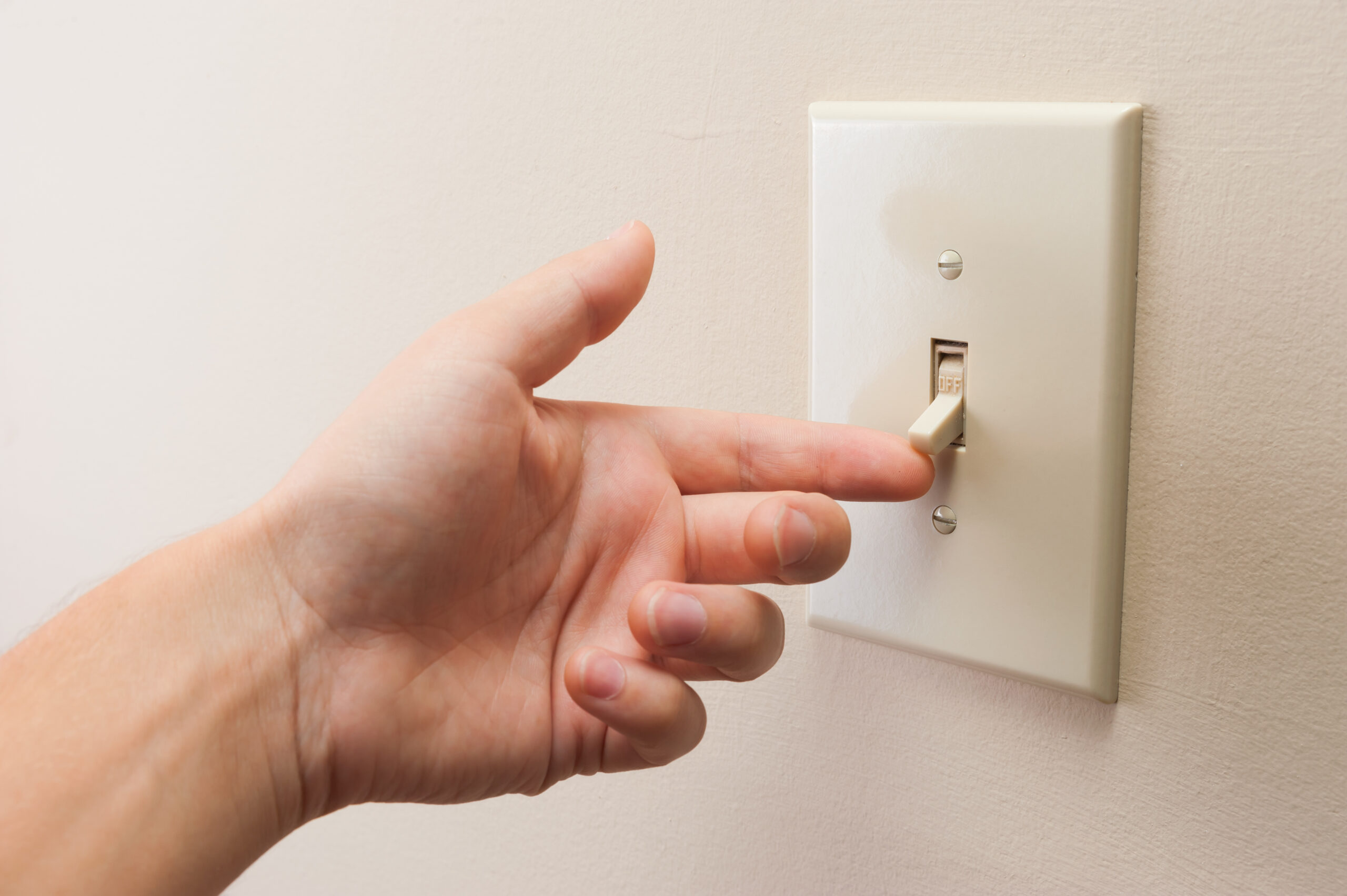 Person Turning On Light Switch | Jason Wright Electric